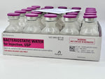 Five bottles of Henry Schein 30ml Bacteriostatic Water are arranged in a row, each featuring a pink and white label and a pink cap.